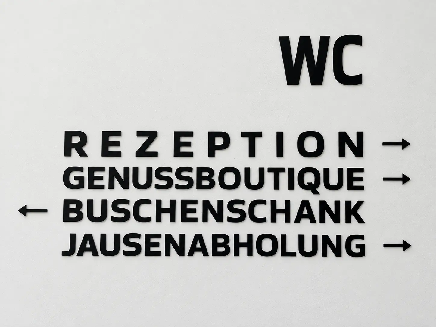 Individuelles Leitsystem mit schwarzen Wandbuchstaben